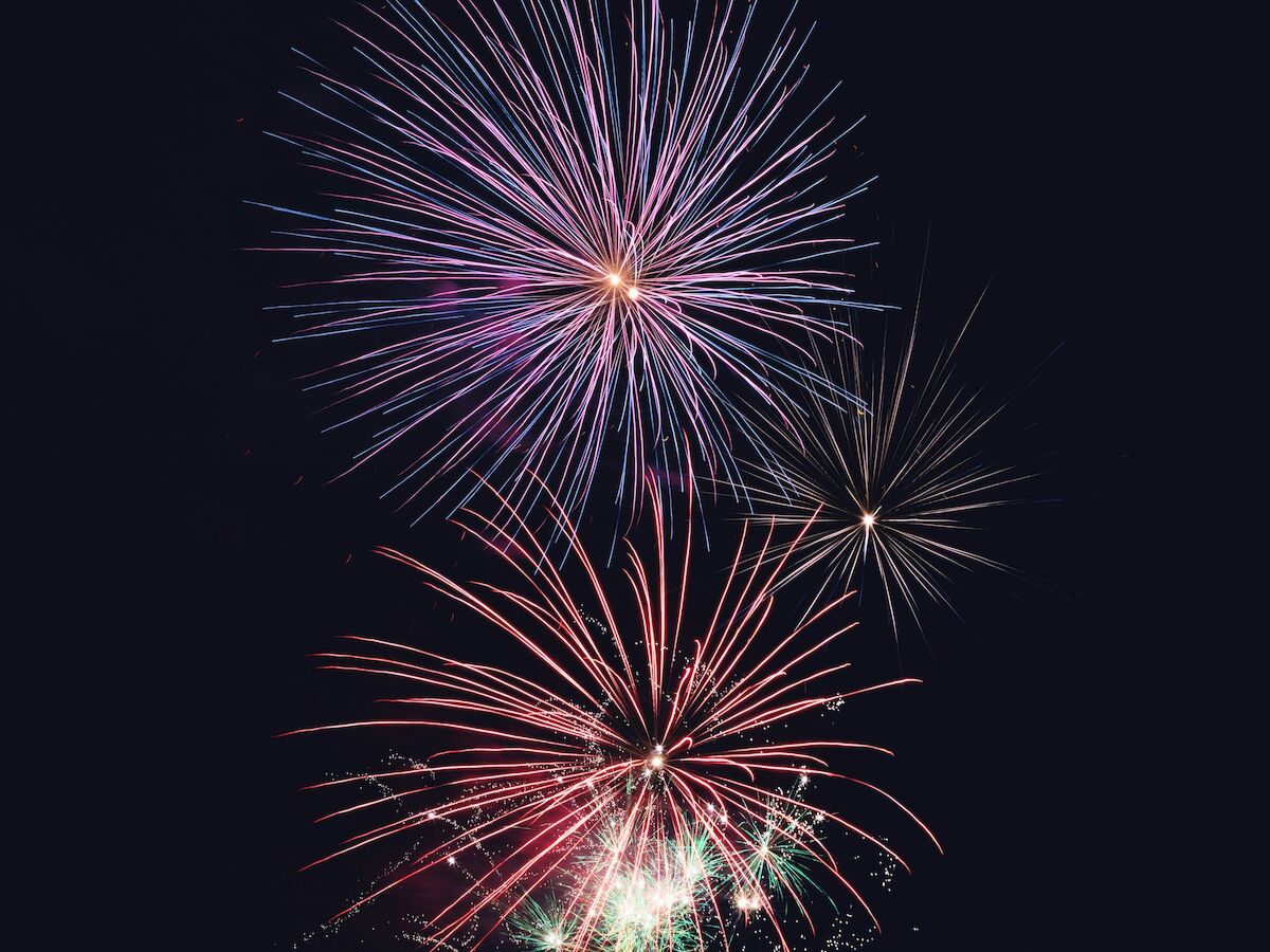 The image shows colorful fireworks exploding against a dark night sky.
